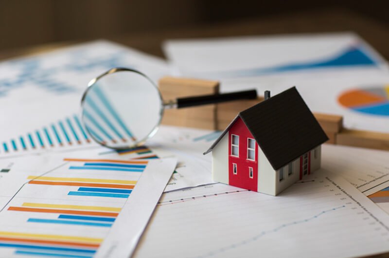 miniature home on financial graph - why house is bad investment - financial planning farmington